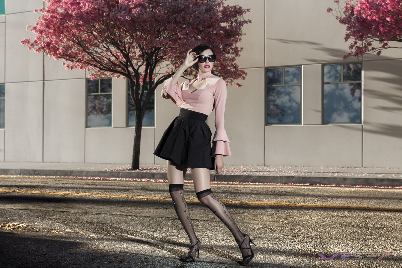 Model Yesenia Osuna in a peach open-front collar top with flared cuffs, a black skirt and knee-high stockings Model Yesenia Osuna in a peach open-front collar top with flared cuffs, a black skirt and knee-high stockings