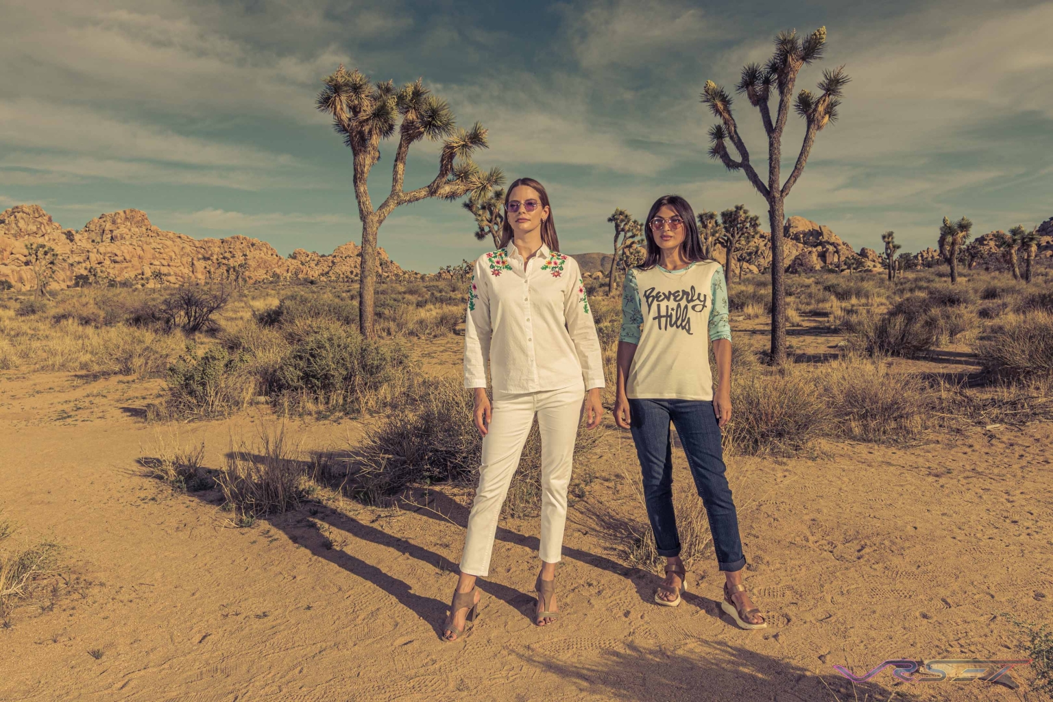 Two models in a floral shirt with white trousers and a two-tone t-shirt with jeans, at Joshua Tree