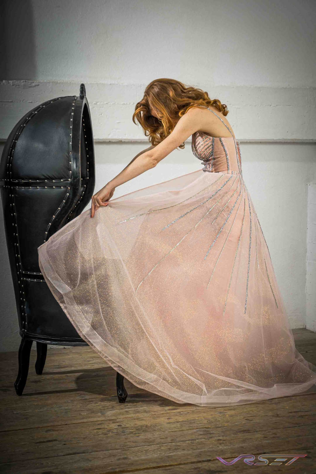 Model in a peach chiffon gown set with crystal studs, lit for an editorial studio frame Model in a peach chiffon gown set with crystal studs, lit for an editorial studio frame