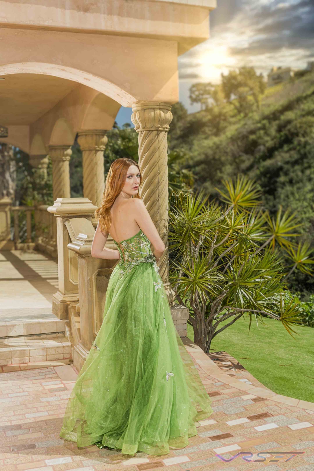 Model in a green chiffon gown standing inside a mansion interior Model in a green chiffon gown standing inside a mansion interior