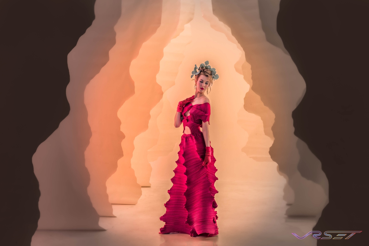 Model wearing a designer dress on a Gaia-inspired theme against a plain studio editorial backdrop Model wearing a designer dress on a Gaia-inspired theme against a plain studio editorial backdrop